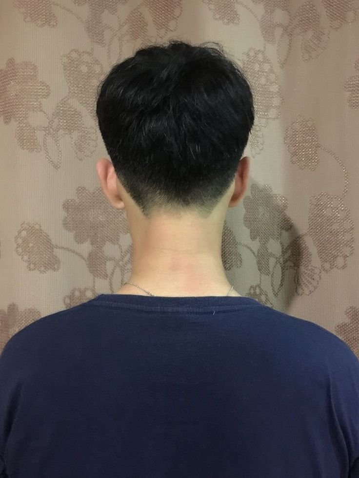 A clean male model with a tapered undercut haircut looking professional and fashion-forward.